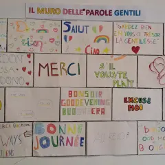 Il muro delle parole gentili: "La gentilezza è un gesto rivoluzionario". Frasi gentili in inglese e altre lingue celebrano la cortesia.