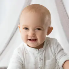 Ein strahlendes Babygesicht, das neugierig in die Welt blickt. So ähnlich sehen Babys mit 1 Woche, wenn sie ihre Umgebung erkunden.