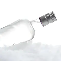 Szklana butelka wódki leży na lodzie, tworząc wrażenie, kiedy wódka zamarza.