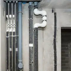 Instalacja wodna w bloku, z widocznymi rurami i izolacją. Może być przyczyną hałasu w rurach od wody w bloku.