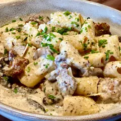 Un plat de pâtes aux champignons, une recette italienne crémeuse et savoureuse, garnie de persil frais.