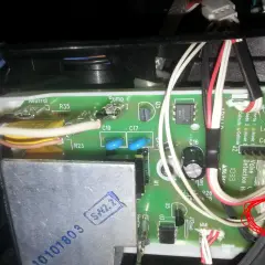 Wnętrze ekspresu Dolce Gusto, gdzie **ekspres Dolce Gusto nie pobiera wody**. Widoczna zielona płytka drukowana z przewodami i elementami elektronicznymi.