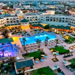 Widok z lotu ptaka na hotel Vincci Dar Midoun. Basen, leżaki, palmy i budynki hotelowe tworzą idealne miejsce na wakacje.