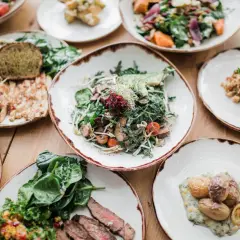 Variedad de platos saludables, incluyendo una ensalada de verdel con aguacate, pollo a la parrilla, quinoa y patatas asadas.
