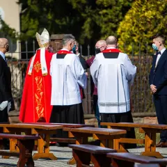 Biskup w czerwonej kapie i ministranci podczas ceremonii bierzmowania.
