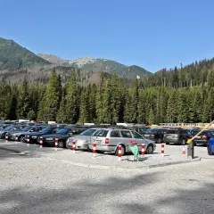 Parking pod Tatrami, tuż przed szlakiem na Morskie Oko. Samochody czekają na turystów.