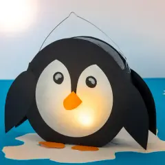 Ein süßer, selbstgebastelter Pinguin als Laterne leuchtet warm. Perfekt zum Basteln für Kinder!