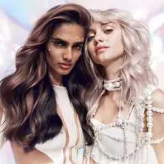Deux femmes aux cheveux magnifiques, l'une brune avec des reflets roses, l'autre blonde platine. Un avant-après de la coloration Dialight Clear, sublimant leur éclat.