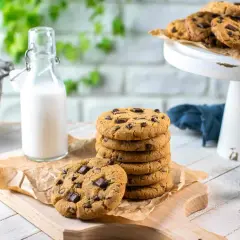 Una pila di biscotti con gocce di cioccolato, pronti per essere gustati con un bicchiere di latte.
