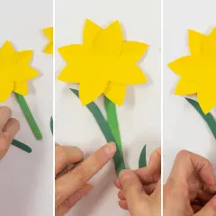 Schritt-für-Schritt-Anleitung zum Narzisse basteln mit Papier. Hände kleben grüne Blätter an den Stiel einer gelben Papiernarzisse.