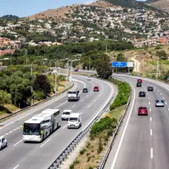 Voiture sur autoroute en Espagne, respectant la limitation vitesse espagne. Paysage vallonné avec des maisons en arrière-plan.