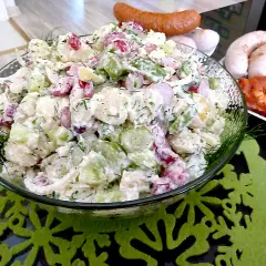 Pyszna sałatka na grilla z ziemniakami, ogórkiem i rzodkiewką, udekorowana koperkiem. Idealna do kiełbasek i mięsa z rusztu.