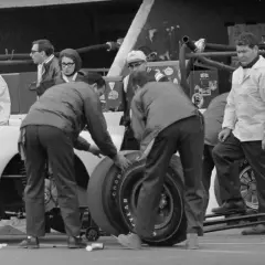 Zespół mechaników przy Fordzie GT40 podczas wyścigu Le Mans 1966. W tle widać kierowcę w kapeluszu kowbojskim.