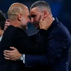 Pep Guardiola i Ryan Giggs w uścisku, symbolizującym szacunek i rywalizację, która wpływa na rankingi Man City.