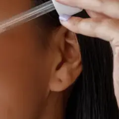 Frau trägt ein Serum mit Linolsäure auf, um ihre Haut zu pflegen.