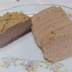 Pokrojony pasztet wieprzowy na talerzu z ozdobnym wzorem.