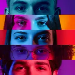 Occhi di persone diverse, illuminati da luci che ricordano quali sono i tre colori primari: rosso, giallo e blu.