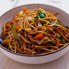 En skål med utsökt chow mein, full av nudlar, grönsaker och böngroddar.