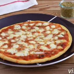 Pizza de garbanzos con queso derretido y salsa de tomate, lista para disfrutar.