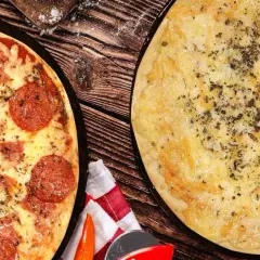 Dos pizzas recién horneadas, una de pepperoni y otra de queso, listas para disfrutar en la pizzeria Carboneras.