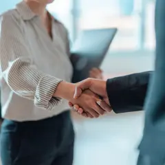 Una stretta di mano che sigilla un accordo, un momento di connessione e attrazione professionale in un ambiente d'ufficio.