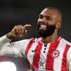 Uśmiechnięty Igor Thiago, piłkarz Brentford FC, pokazuje palcem w górę.