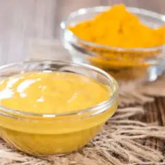 Dwie miseczki z żółtymi przyprawami. Jedna zawiera gęstą pastę, druga proszek. Idealne, gdy zastanawiasz się, czym zastąpić pastę curry.