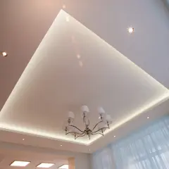 Nowoczesne aranżacje sufitów podwieszanych z subtelnym podświetleniem LED i eleganckim żyrandolem. Wzory tworzą przestrzeń.