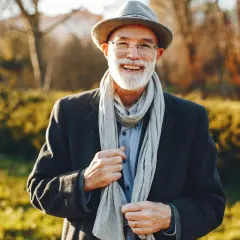 Uśmiechnięty starszy pan w kapeluszu i szaliku, jakby z mojego snu o zmarłym ojcu.
