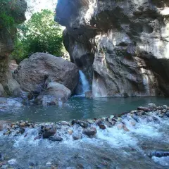 Un rincón idílico en las cascadas de Padules, Almería, donde el agua cristalina fluye entre rocas y vegetación exuberante.