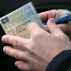 Ręce trzymają dowód rejestracyjny pojazdu z Zielonej Góry, gotowe do kontroli lub wypełnienia.