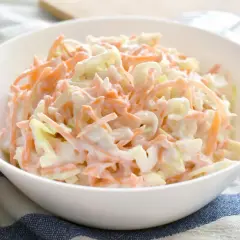 En skål med krämig coleslaw, perfekt som tillbehör till grillat. Den här godaste coleslawen är en klassiker som passar till det mesta.