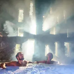 Para spędza relaksujący weekend we dwoje w jacuzzi, otoczona parą i światłem wpadającym przez okna.