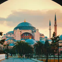 Blick durch einen Torbogen auf die Hagia Sophia mit ihren Kuppeln und Minaretten im Abendlicht. Der Eintritt in dieses historische Meisterwerk ist ein unvergessliches Erlebnis.