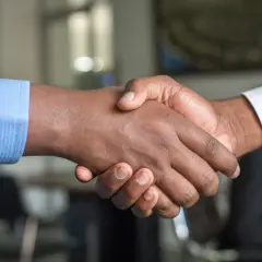 Dos hombres se dan la mano, sellando un acuerdo. Un apretón de manos que podría ser el inicio de un modelo precontrato exitoso.