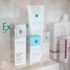 Produkty Exuviance na półce: serum łagodzące i peeling/booster.