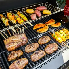 Côtelettes d'agneau, brochettes de légumes et pommes de terre en cuisson barbecue. Un festin en plein air !