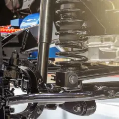 Detalle de la suspensión de un coche, con amortiguador y muelle helicoidal. Ideal para quienes buscan cambiar suspension coche.