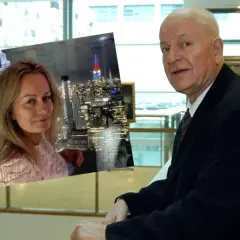 Agnieszka Zduńczyk Machulski na tle nocnego Manhattanu, obok starszy mężczyzna w garniturze.