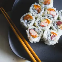 Talerz z sushi, pałeczki i dodatki. Czy sushi tuczy? Zależy od składników i ilości ryżu.