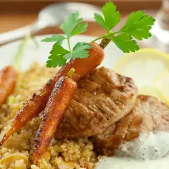 Délicieux grenadin de veau, servi avec des carottes glacées, du boulgour et une sauce crémeuse.