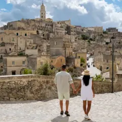 A couple walks through a historic Italian town, a perfect place to base yourself in Puglia.