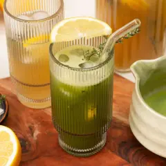 Erfrischender Eistee: Matcha kalt zubereiten mit Zitrone und Minze. Ein Glas mit Eiswürfeln, grüner Flüssigkeit und einer Zitronenscheibe.