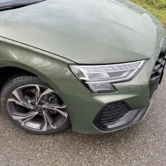 Zielony Audi A3 kombi z felgami S line na mokrej drodze.