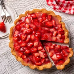 Une part de tarte aux fraises de grand-mère, garnie de fruits frais et de glaçage brillant, prête à être dégustée.