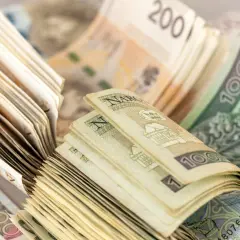 Stosy polskich banknotów 100 zł i 200 zł. Zastanawiasz się, czy wypłacać pieniądze z banku?