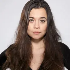 Caroline Ringskog Ferrada-Noli, med sitt långa mörka hår och blick som möter betraktaren, klädd i en svart topp.