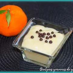 Mousse clémentine mascarpone légère et aérienne, décorée de perles de chocolat. Une clémentine fraîche à côté.