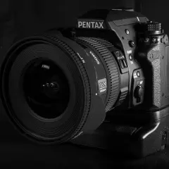 Czarno-białe zdjęcie lustrzanki Pentax K-3 z obiektywem Sigma.
