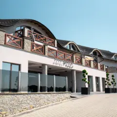 Elegancki hotel Molo Resort z drewnianymi balustradami i kamienną podmurówką. Sprawdź molo resort ceny i zarezerwuj pobyt.